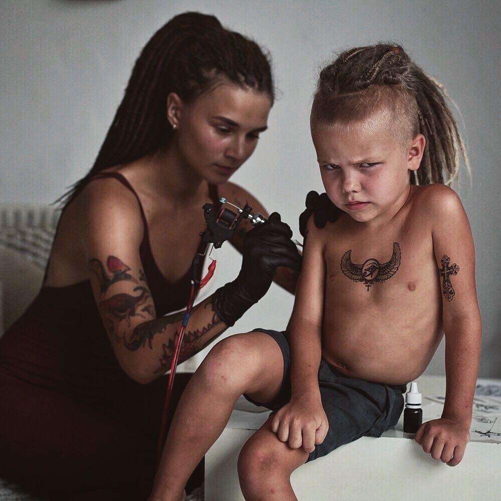 Мальчик с татуировками и дредами